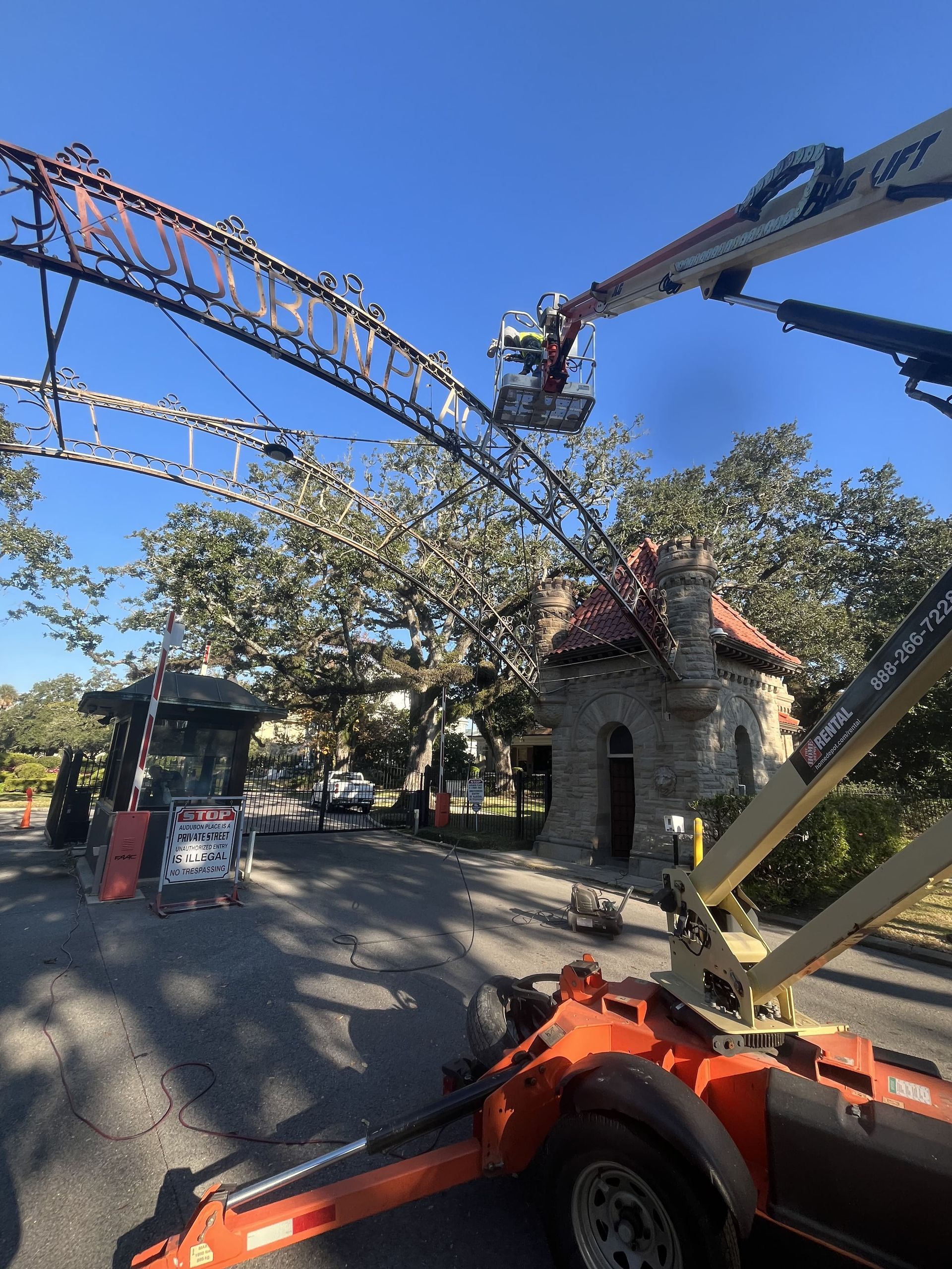 A crane is sitting on top of a trailer in front of a building.