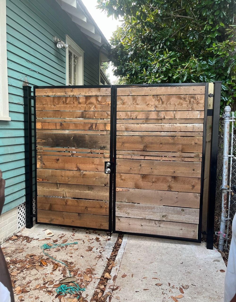 A wooden gate is in front of a blue house