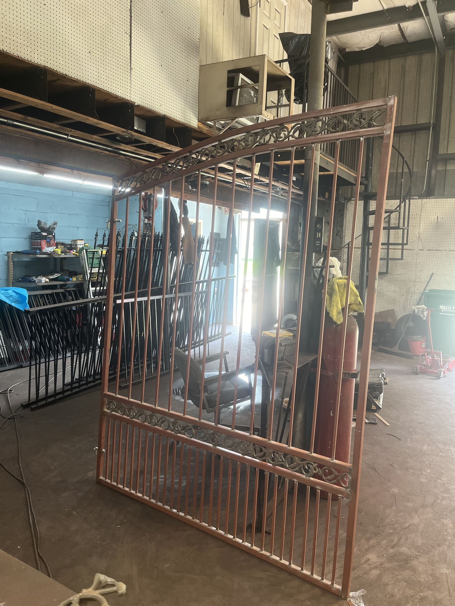 A large metal gate is sitting in a room in a factory.