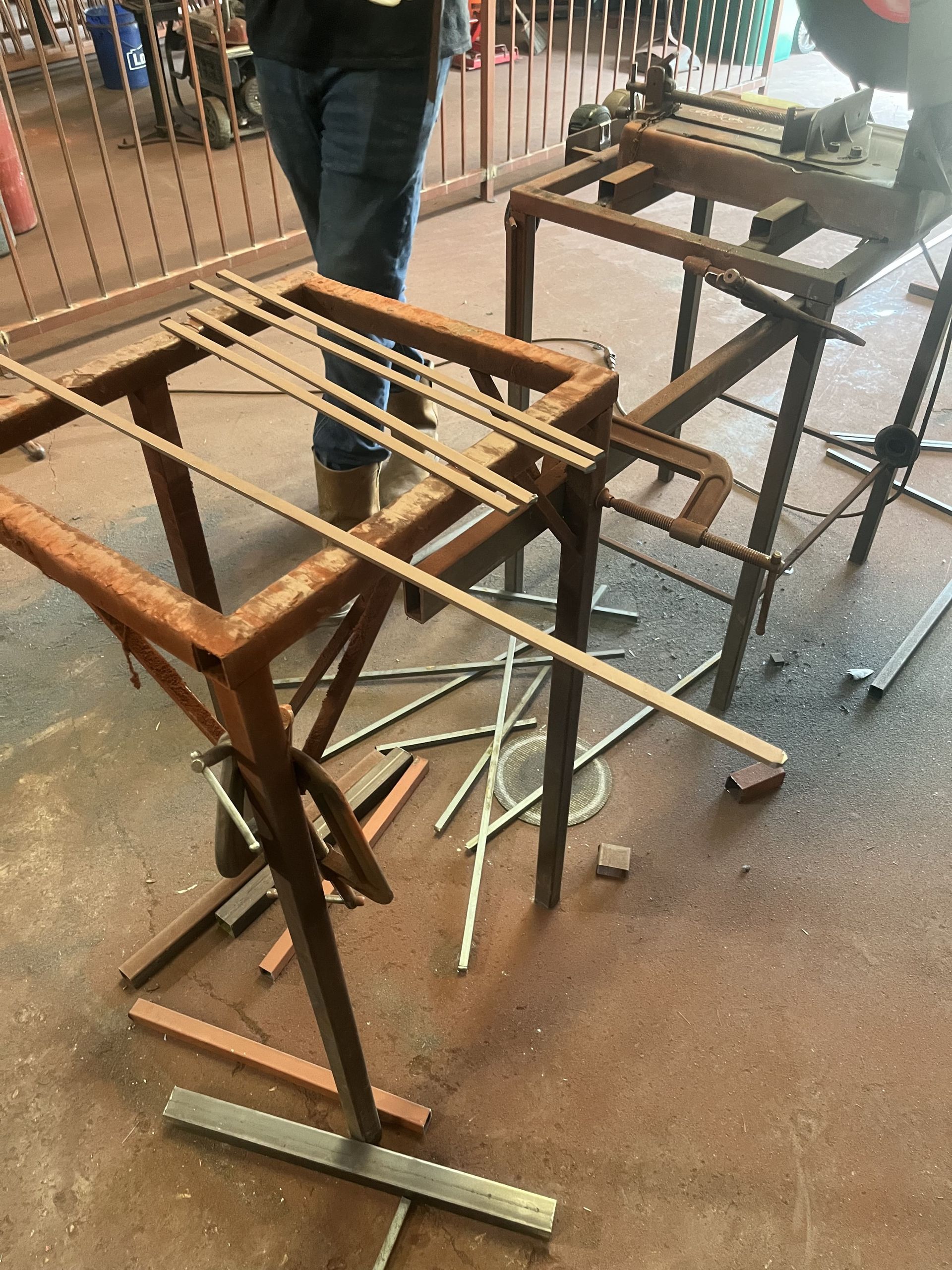 A person is standing next to a wooden table with a bunch of sticks on it.