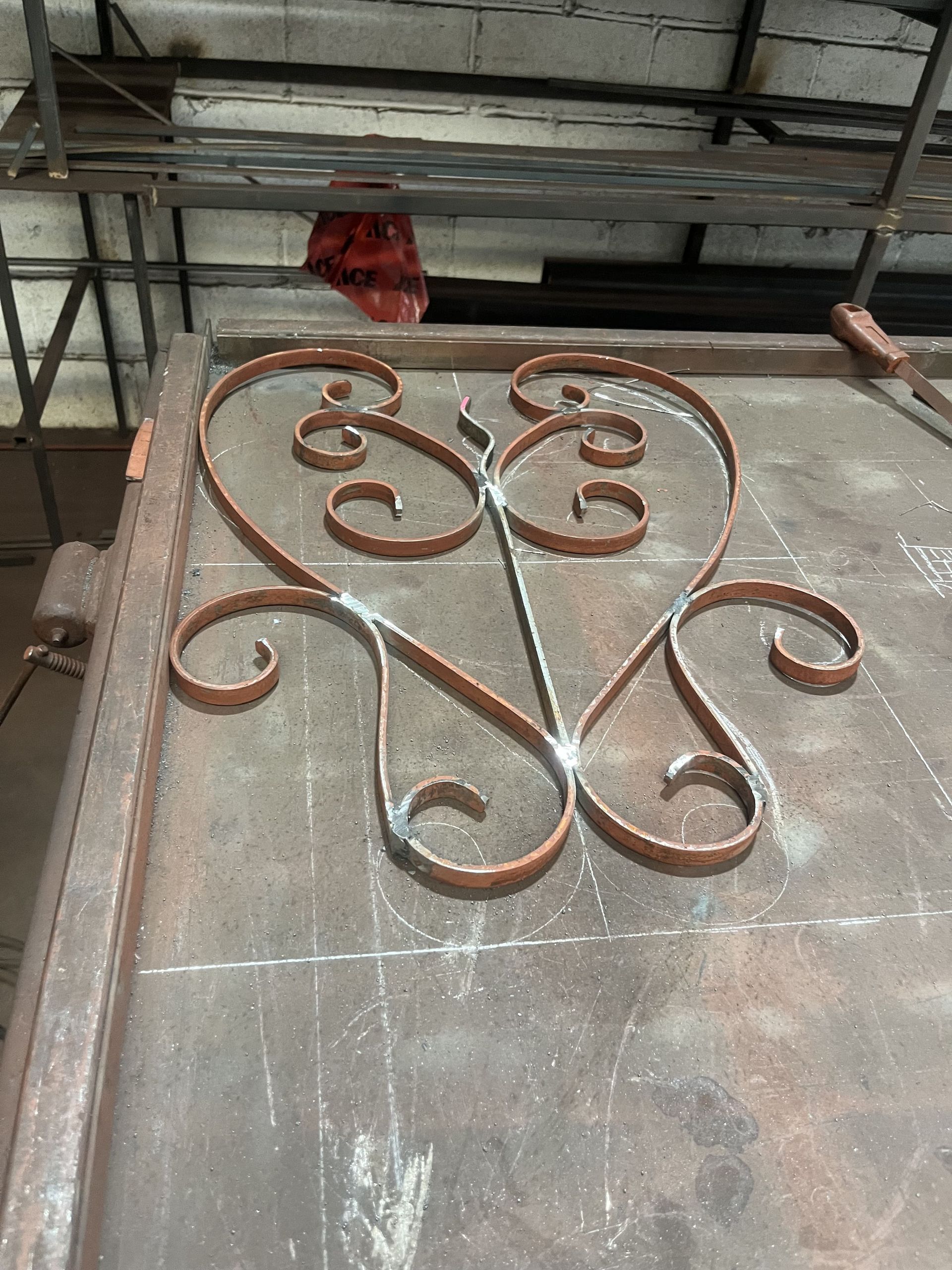A wrought iron design is sitting on top of a wooden table.