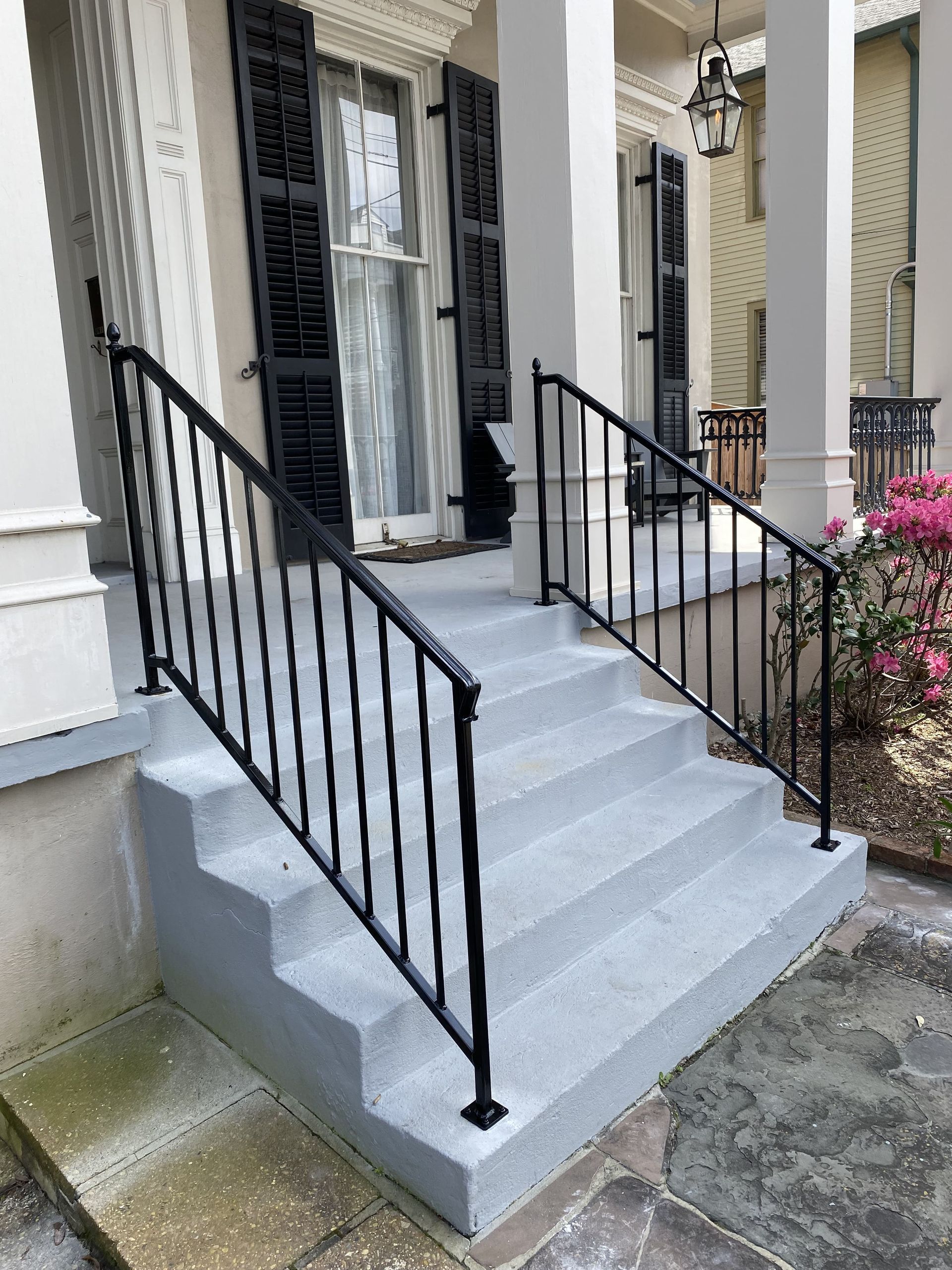 A wrought iron railing on the steps of a house.