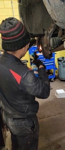 A man is working on a car in a garage.