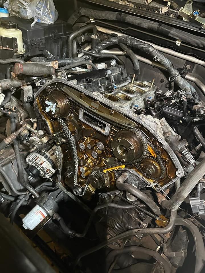 The engine of a car is being worked on in a garage.