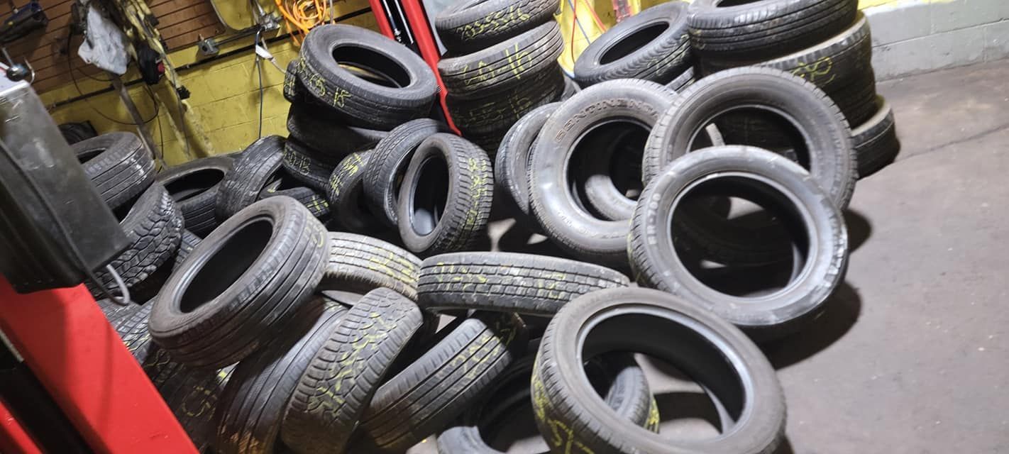 A pile of tires are stacked on top of each other in a garage.