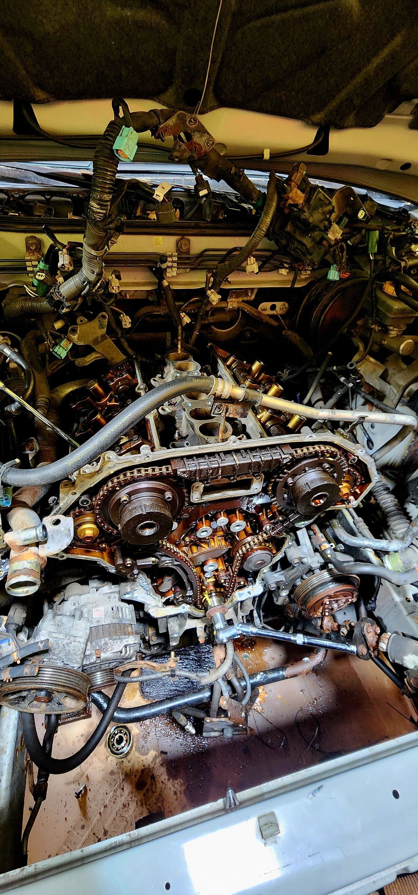 A close up of a car engine with the hood open.