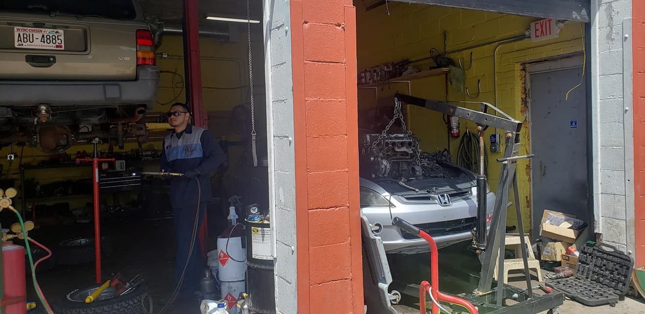 A man is working on a car in a garage.
