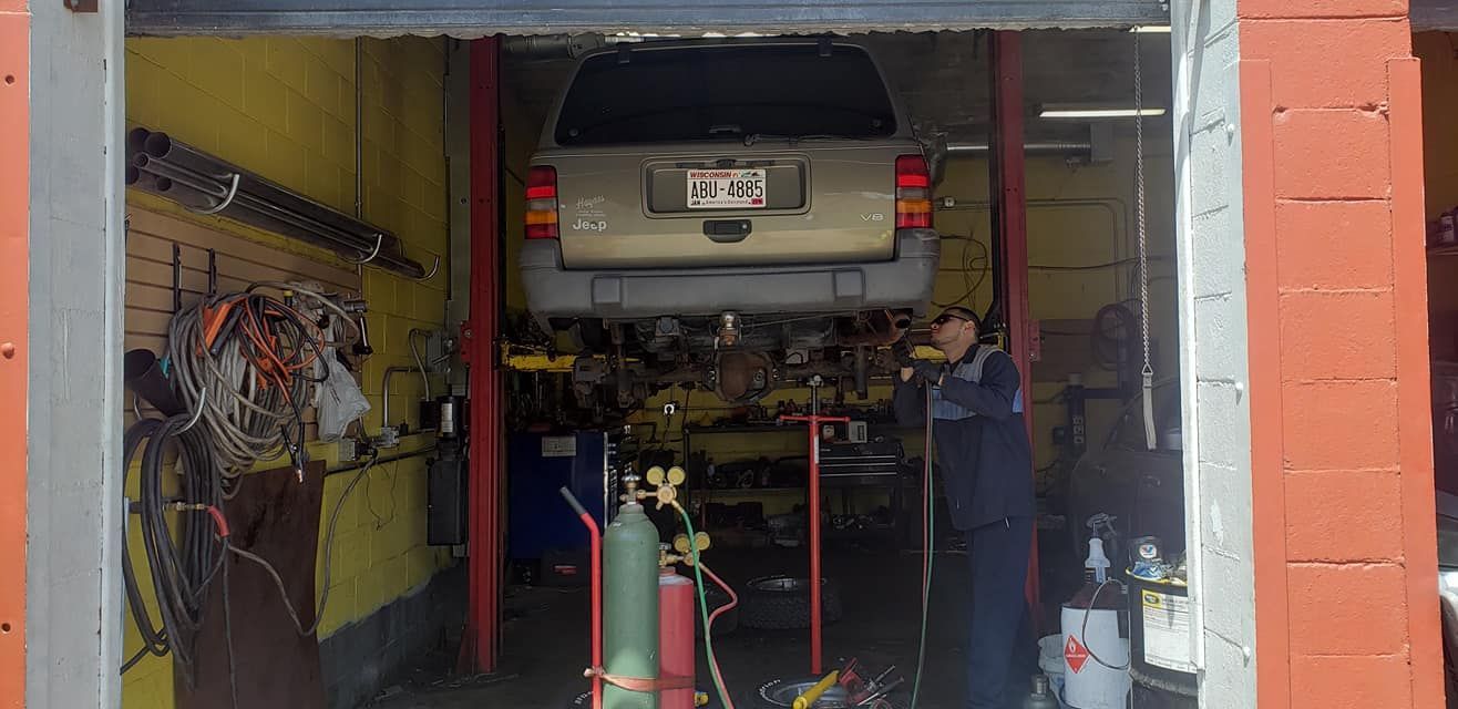 A man is working on a car in a garage.
