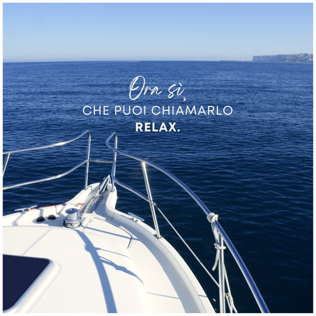 A boat in the ocean with the words ora si che puoi chiamarlo relax