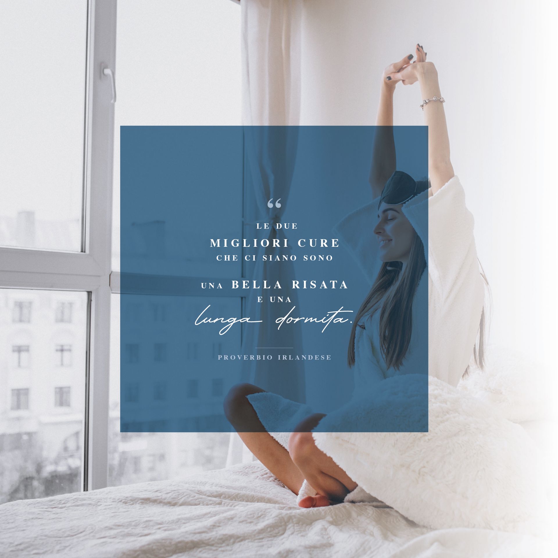 Una donna è seduta su un letto con le braccia alzate