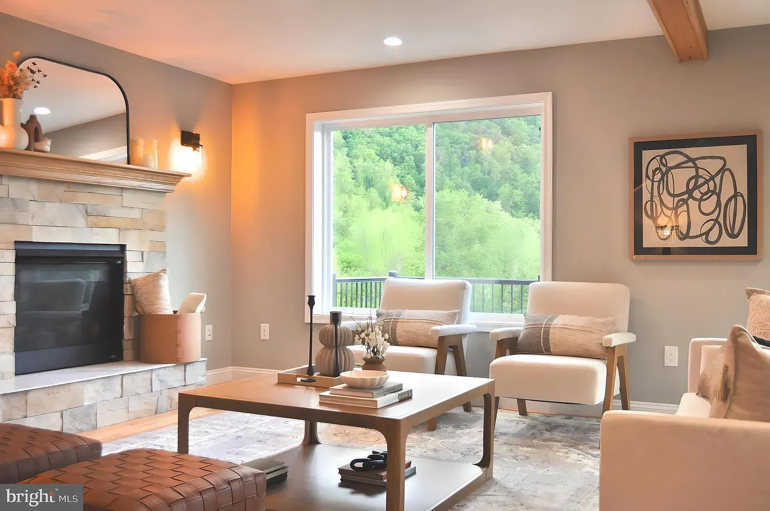 Living room with fireplace, window overlooking greenery, neutral tones, and modern furniture.