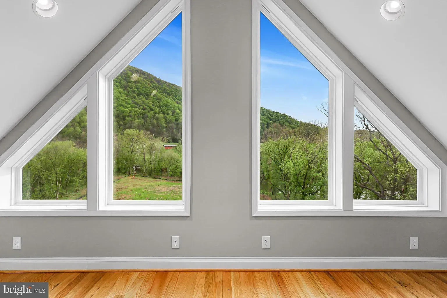 Interior room with large triangular windows framing a mountain view.