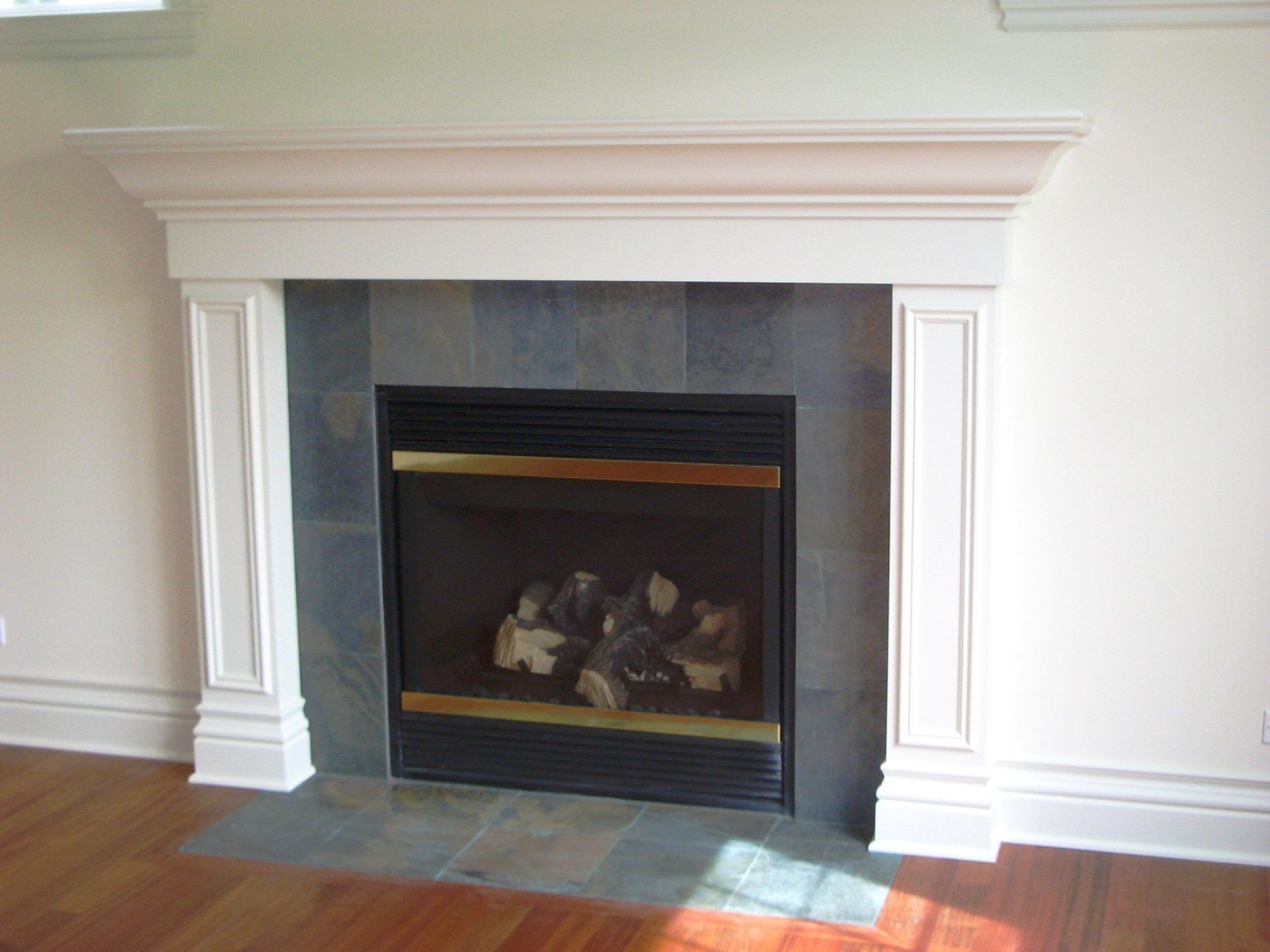 A fireplace with a white mantle in a living room