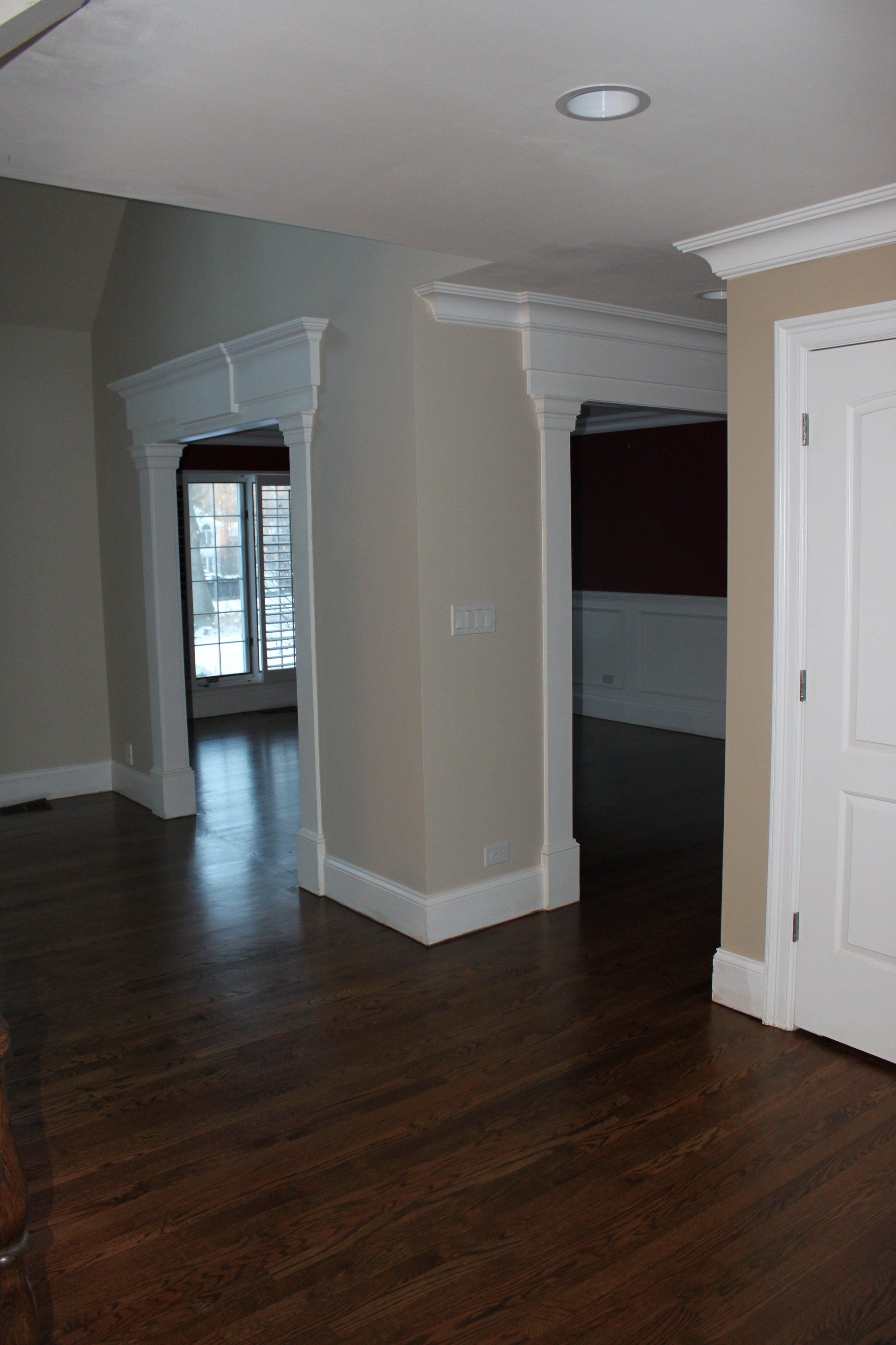 An empty room with hardwood floors and white trim