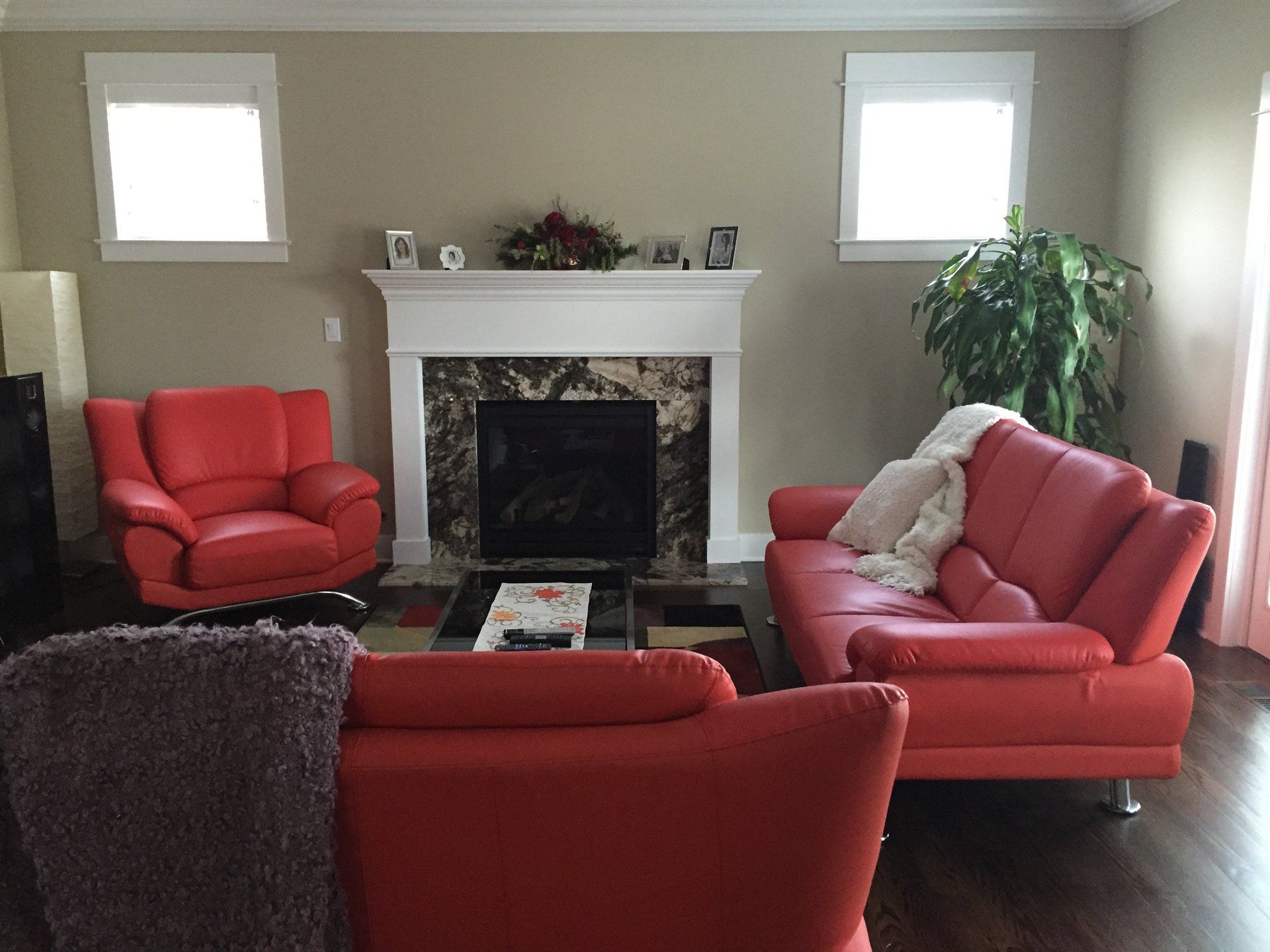 A living room with red furniture and a fireplace