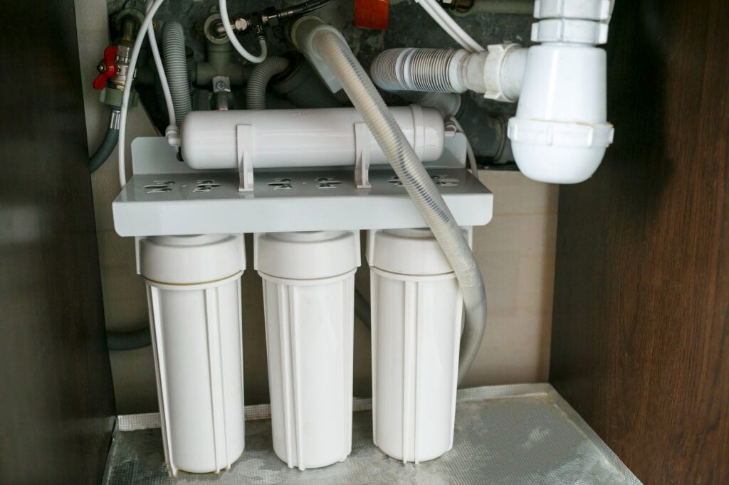 Water Filtration System Under a Sink, With Three White Filter Housings — AD Plumbing & Maintenance in Nicholls, ACT