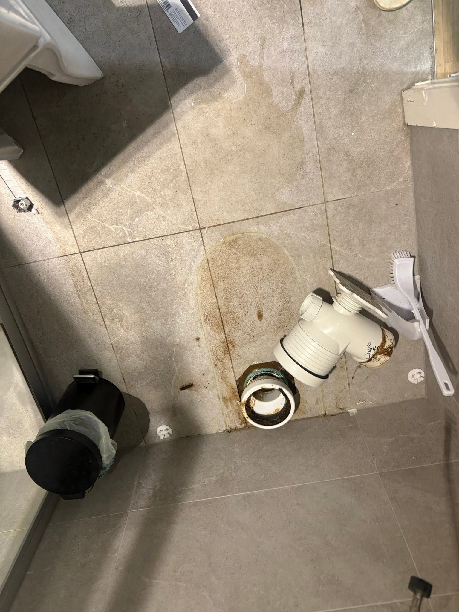 White Container on a Tiled Floor Near a Sink or Cabinet — AD Plumbing & Maintenance in Canberra, ACT