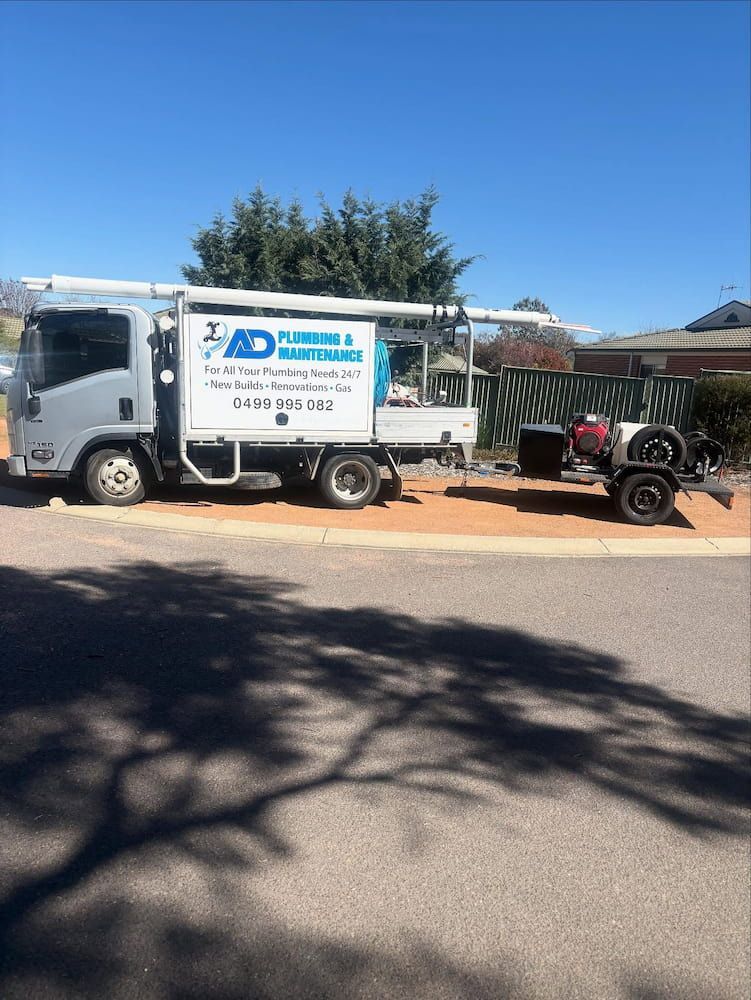 White Plumbing Truck With Trailer Parked on Gravel — AD Plumbing & Maintenance in Nicholls, ACT