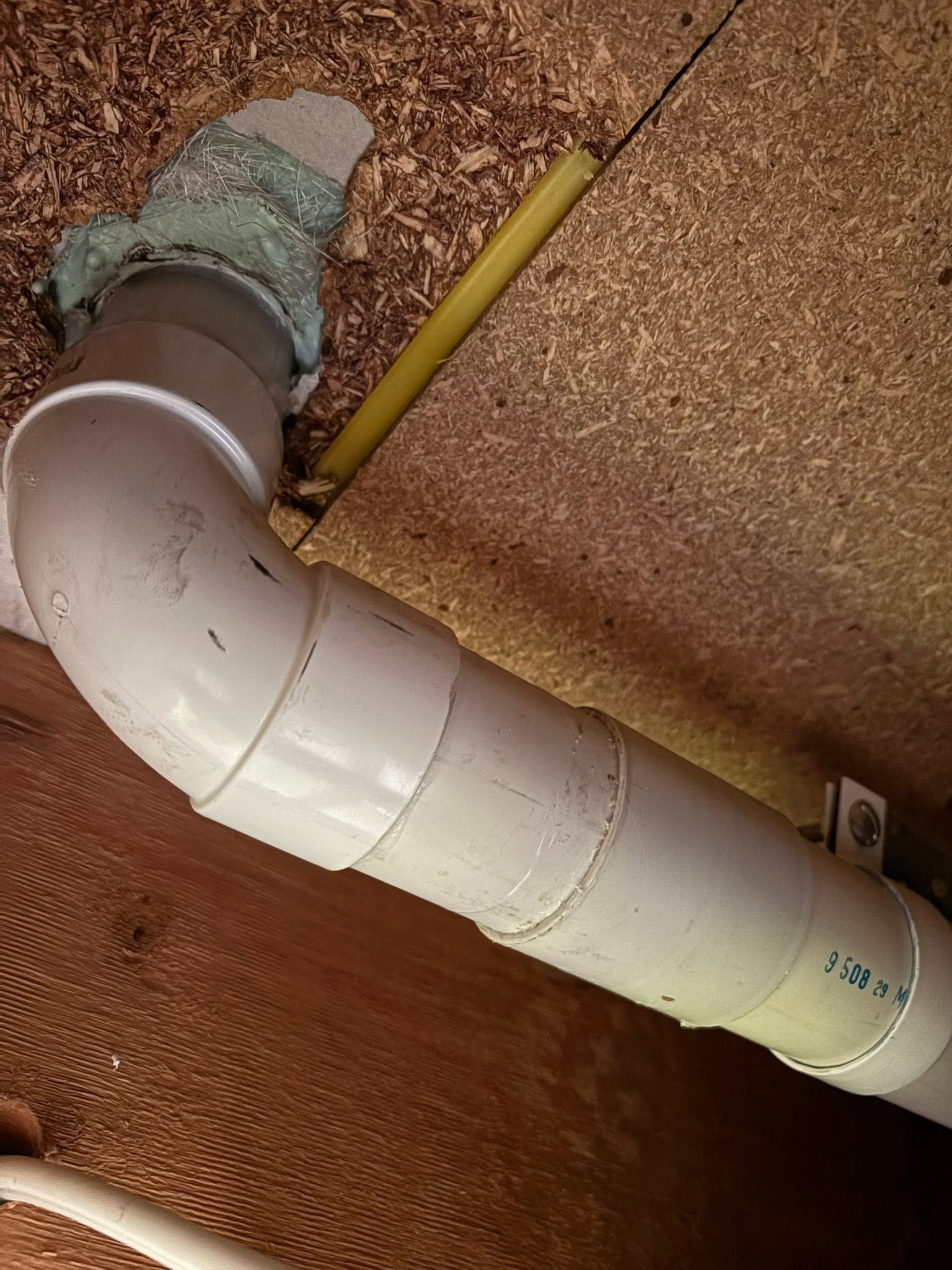 White Pvc Pipe Elbow With a Yellow Pencil Beside It on a Ceiling/Attic Surface — AD Plumbing & Maintenance in Canberra, ACT