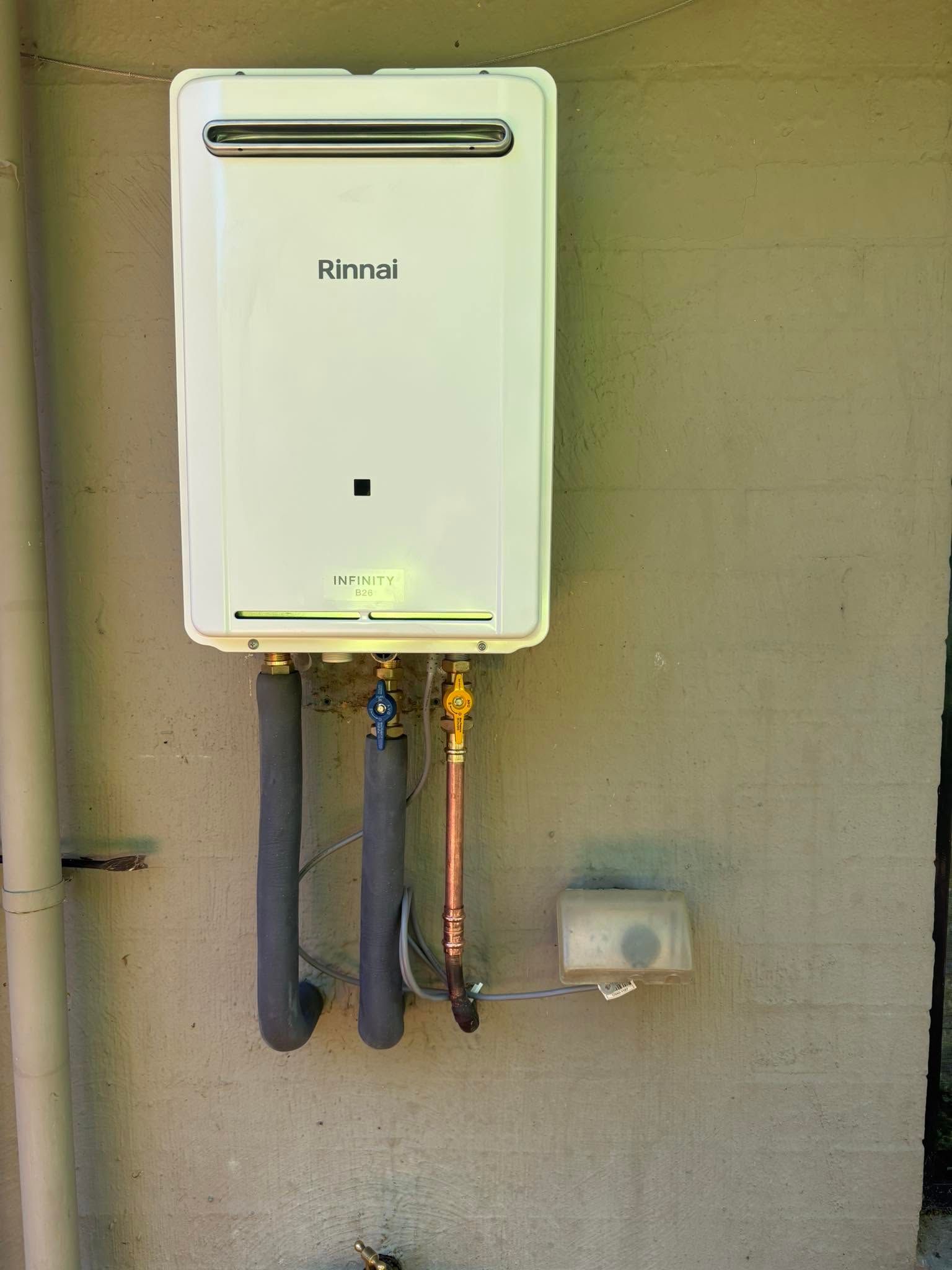 White Wall-mounted Rinnai Water Heater With Exposed Pipes — AD Plumbing & Maintenance in Canberra, ACT