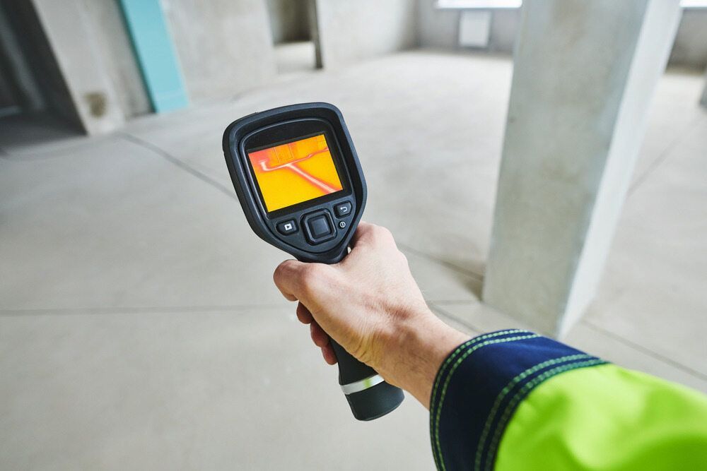 Person Holds a Thermal Imaging Camera in a Construction Site, Scanning a Wall — AD Plumbing & Maintenance in Nicholls, ACT