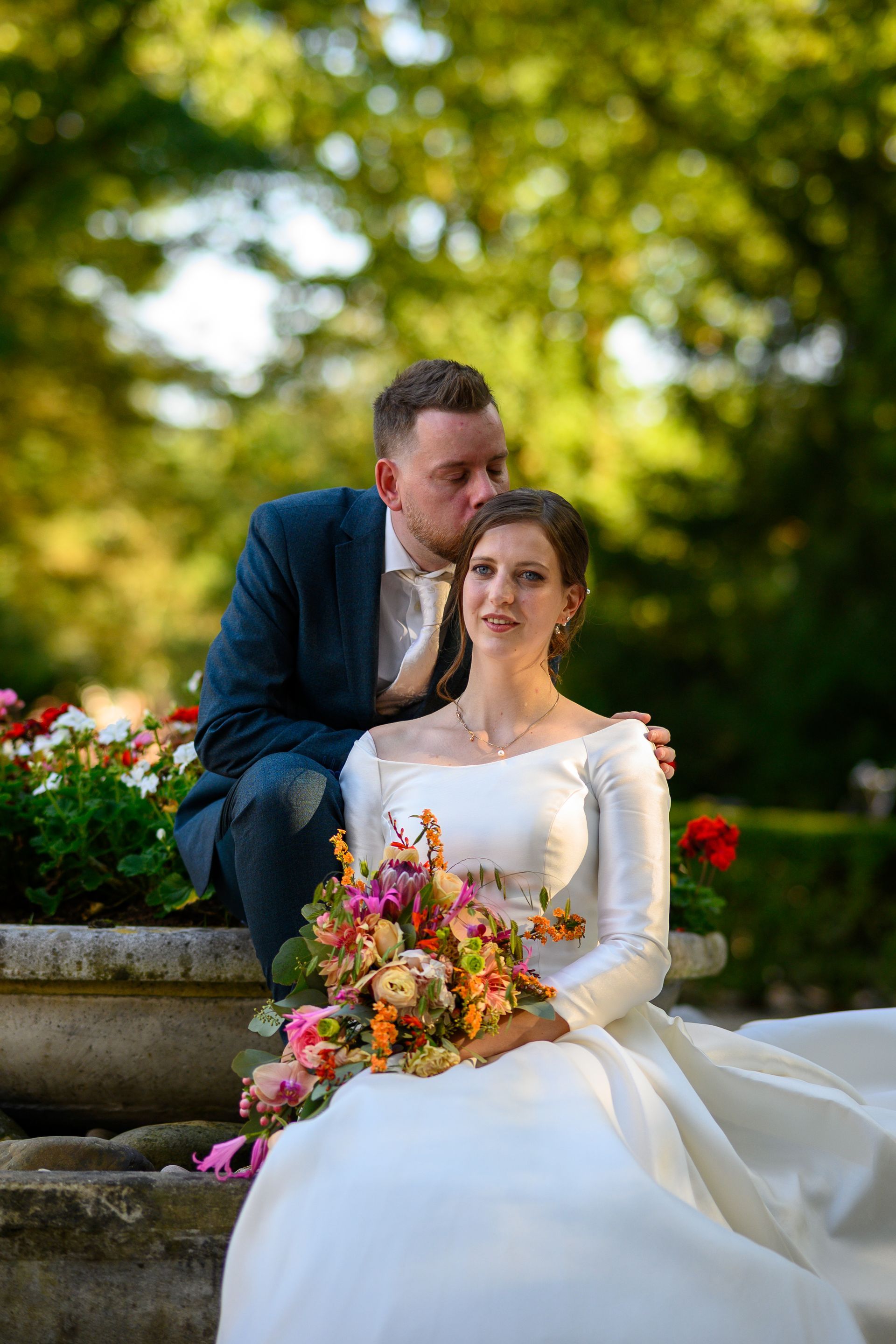 Een bruid en bruidegom poseren voor een foto in een park. M-stand fotografie