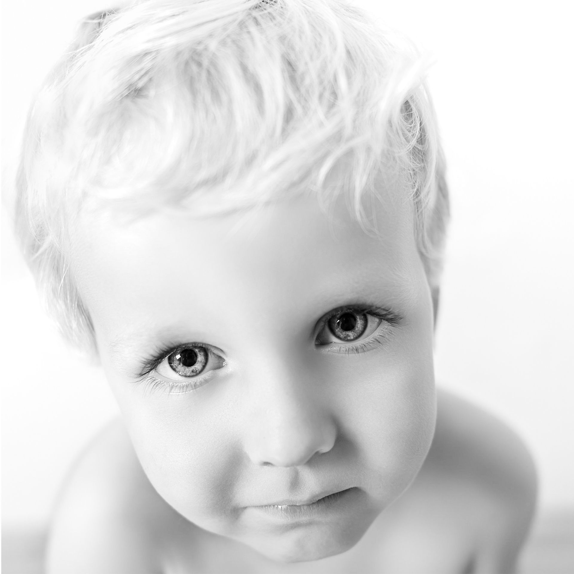 Een zwart-witfoto van een baby die in de camera kijkt. Portretten  M-stand fotografie