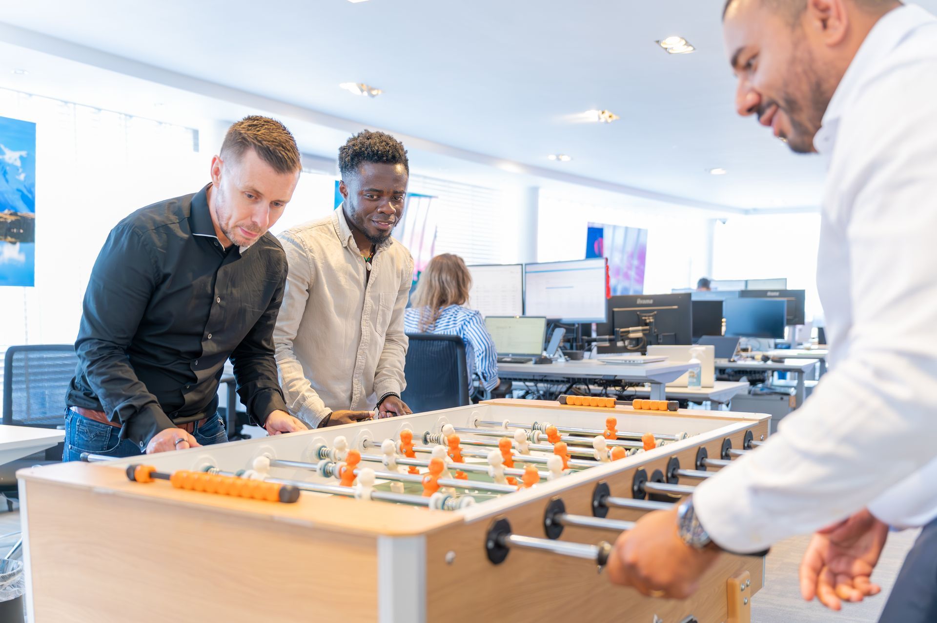 Een groep mannen speelt tafelvoetbal op een kantoor. M-stand fotografie