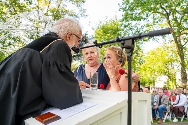 Een man houdt een toespraak voor een groep mensen op een podium. M-stand fotografie