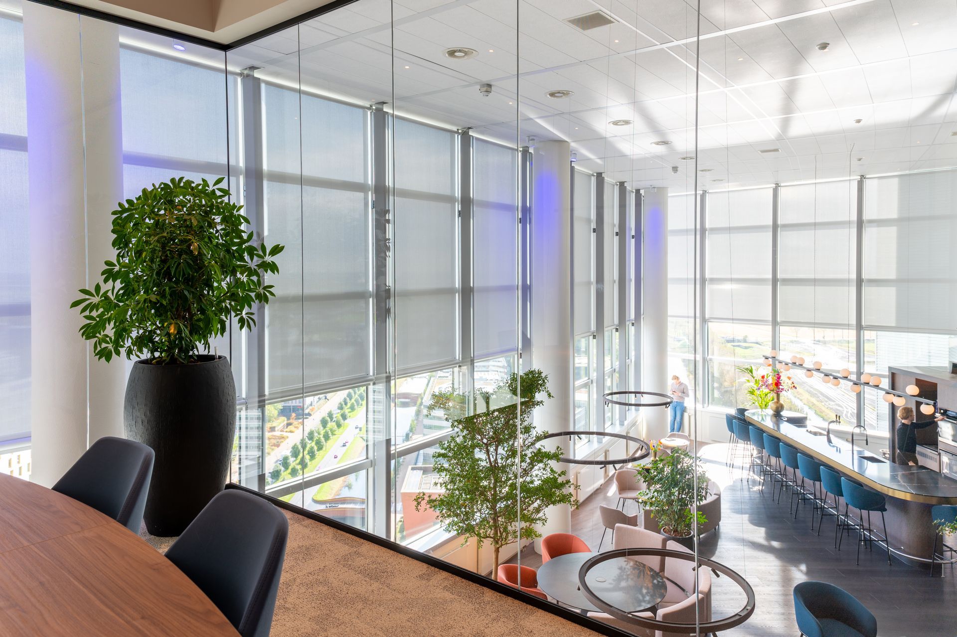 Een grote kamer met veel ramen en een tafel en stoelen. M-stand fotografie