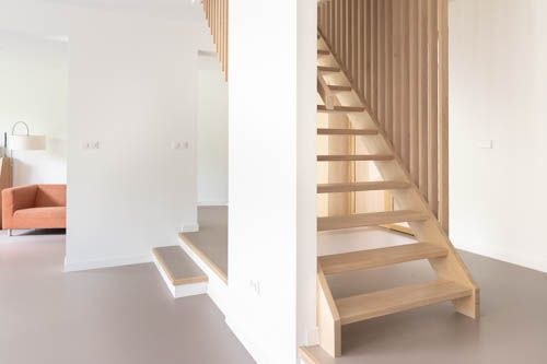 Een houten trap in een woonkamer met een houten leuning.M-stand fotografie