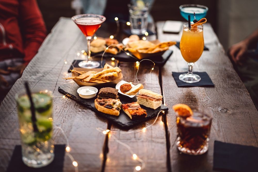 a table topped with a variety of drinks and food .