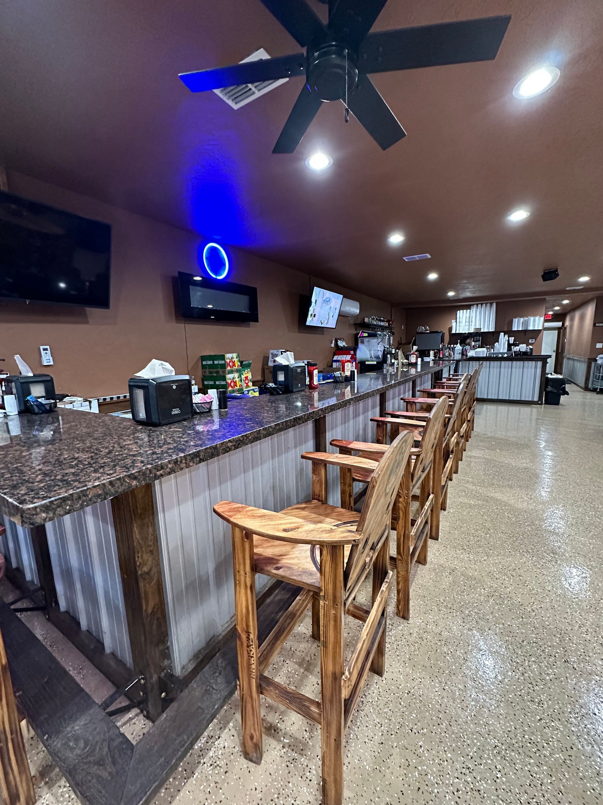 a hamburger and two glasses of beer are on a wooden table .