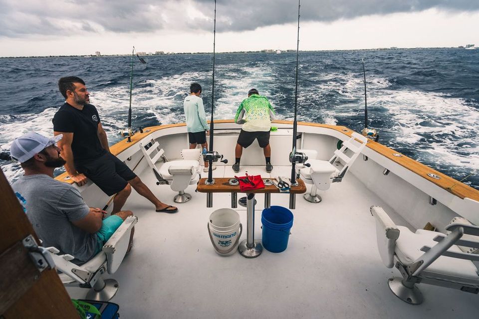 A group of men are fishing on a boat in the ocean.