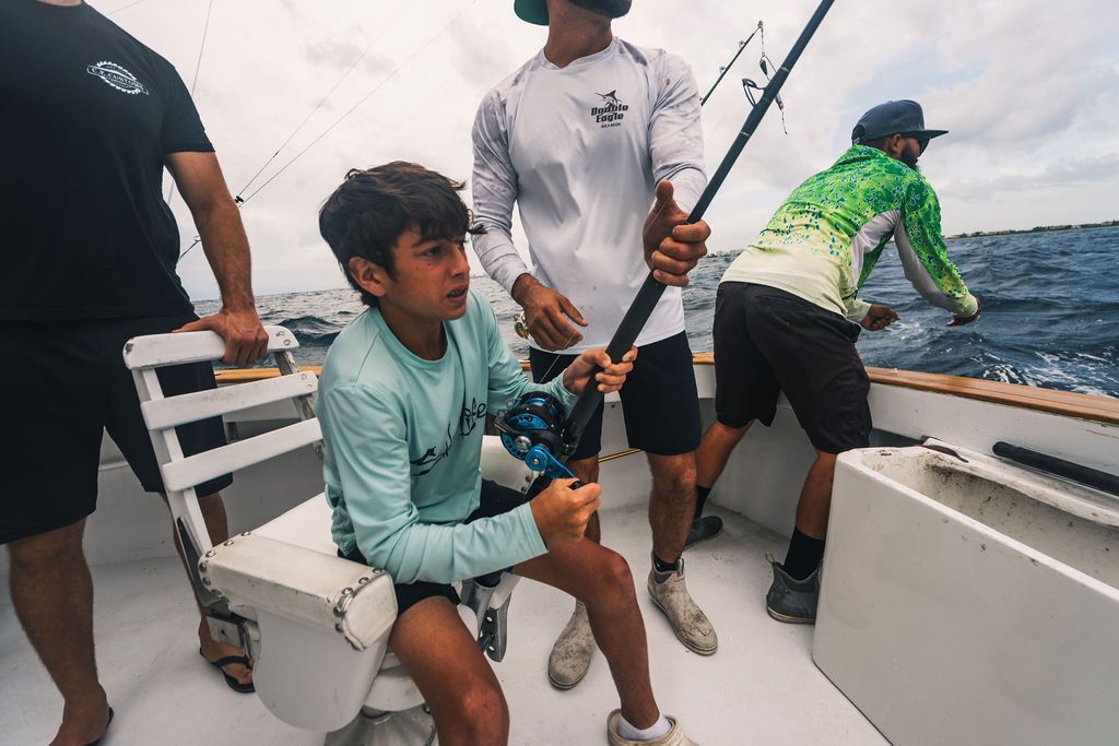 A group of men are fishing on a boat in the ocean.