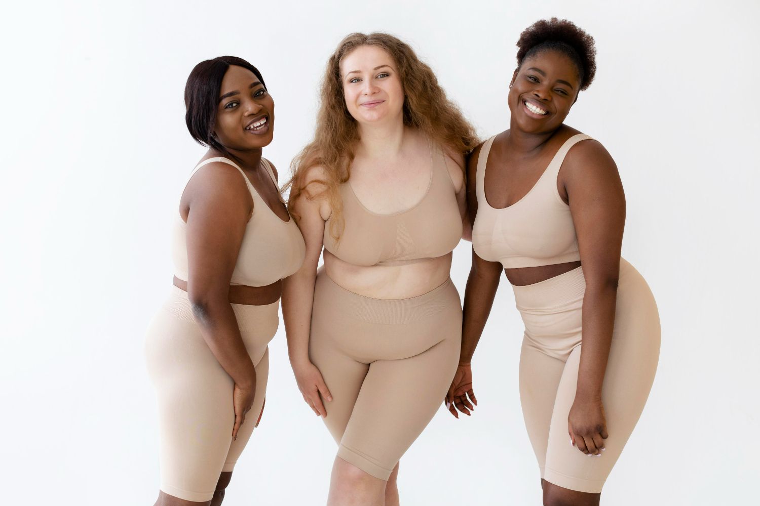 Three plus size women are posing for a picture together.