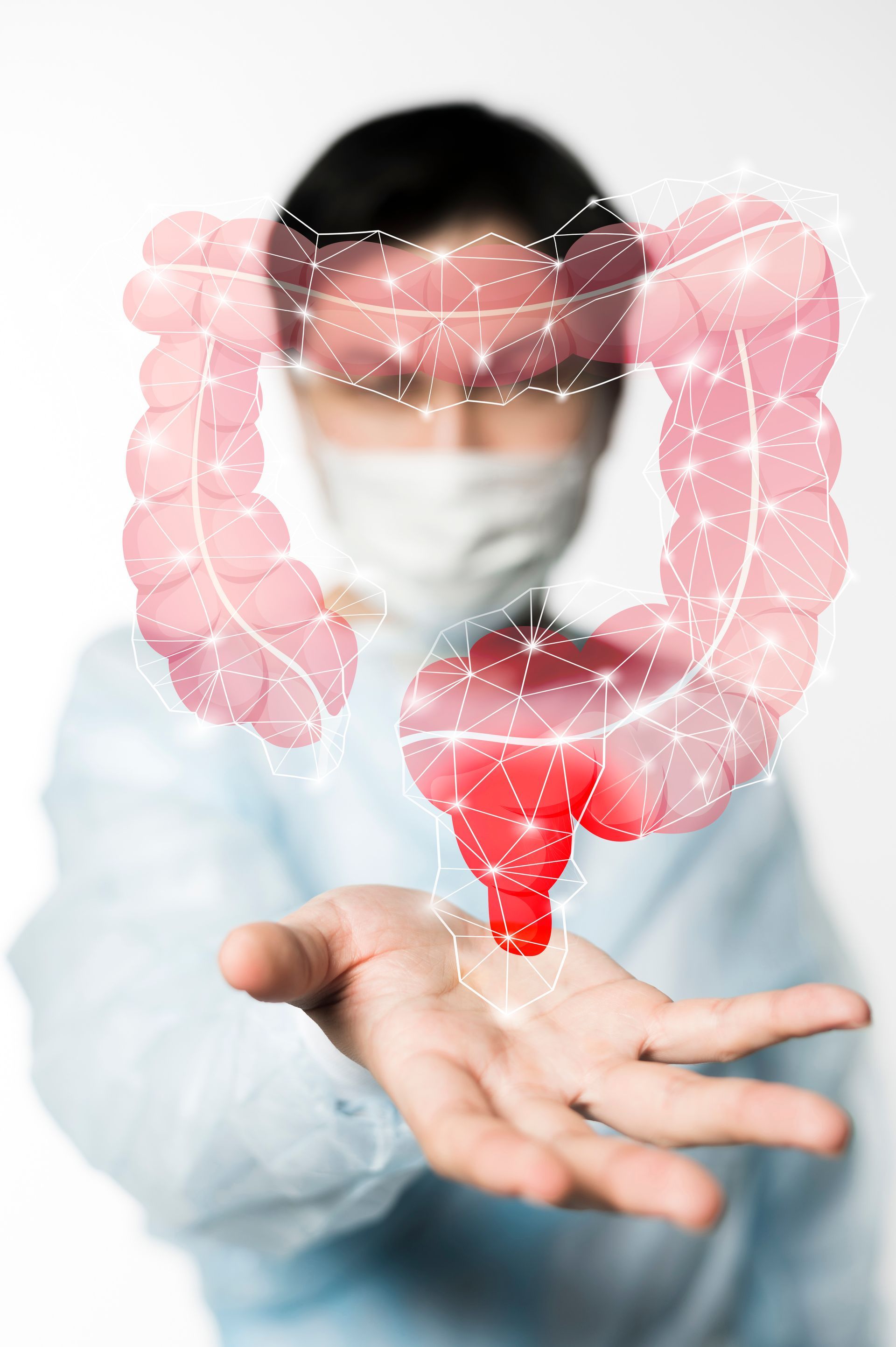 A doctor wearing a mask is holding a large intestine in his hand.