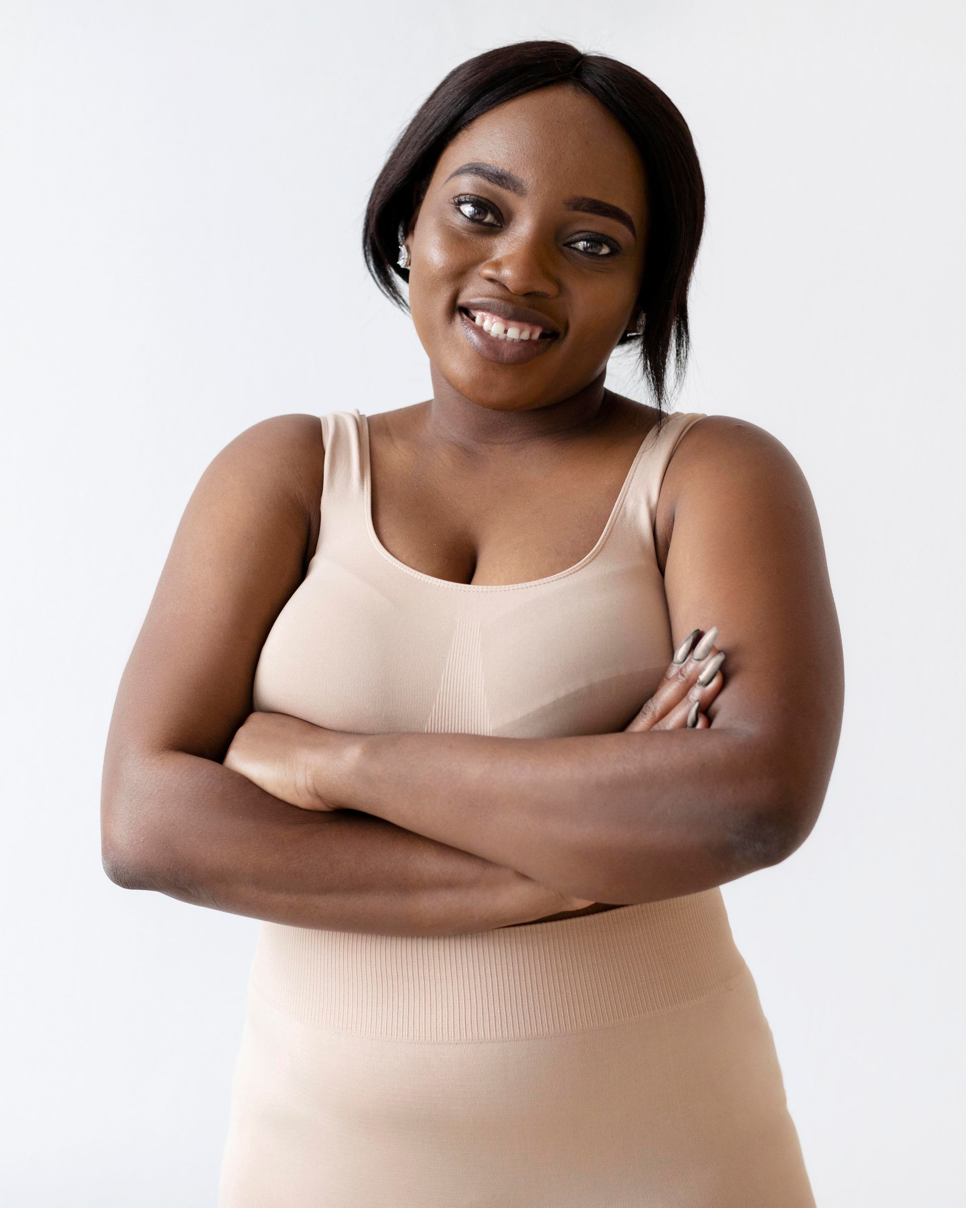 A young woman is holding her stomach and giving a thumbs up sign.