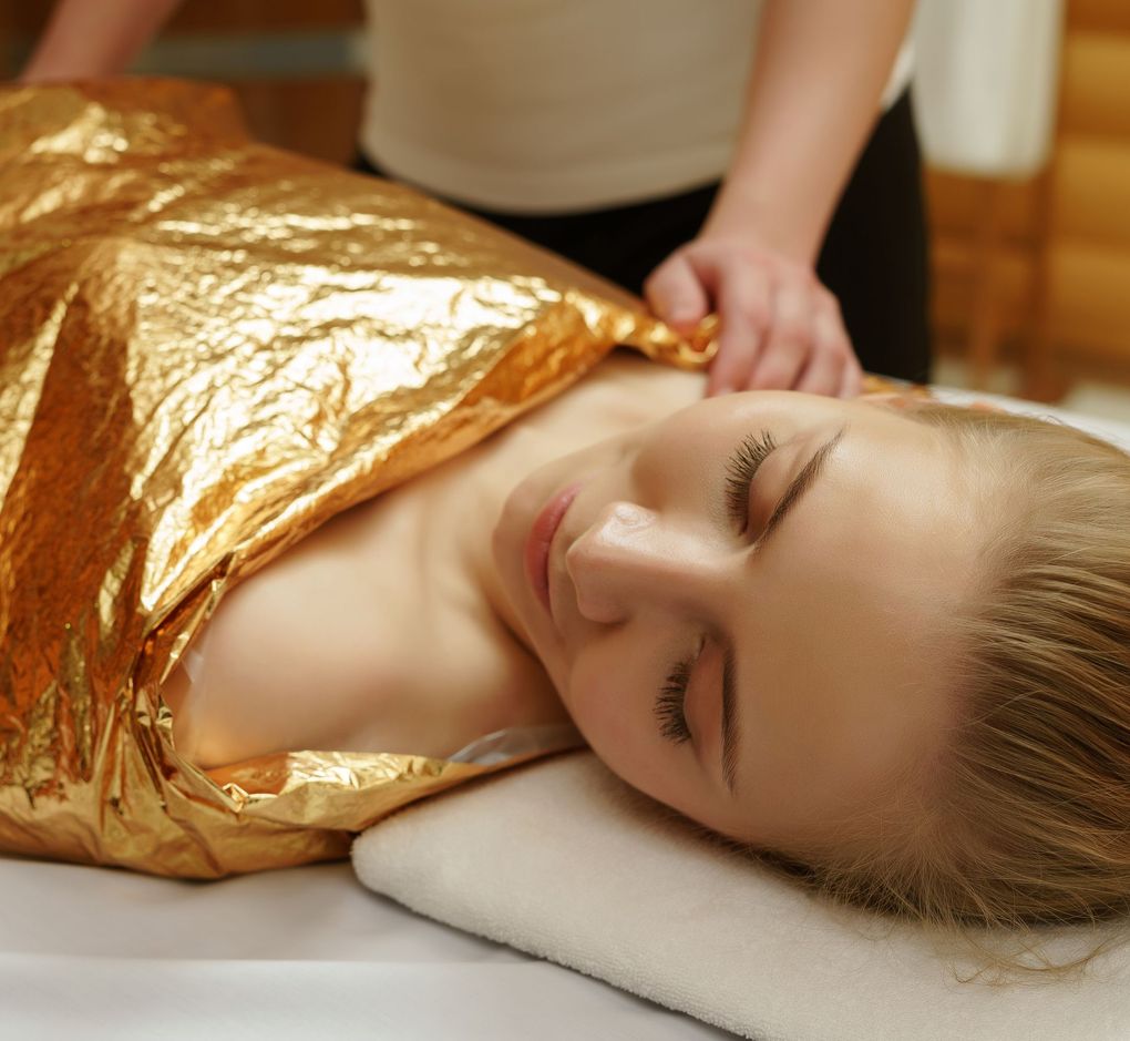 A woman is wrapped in a gold foil blanket