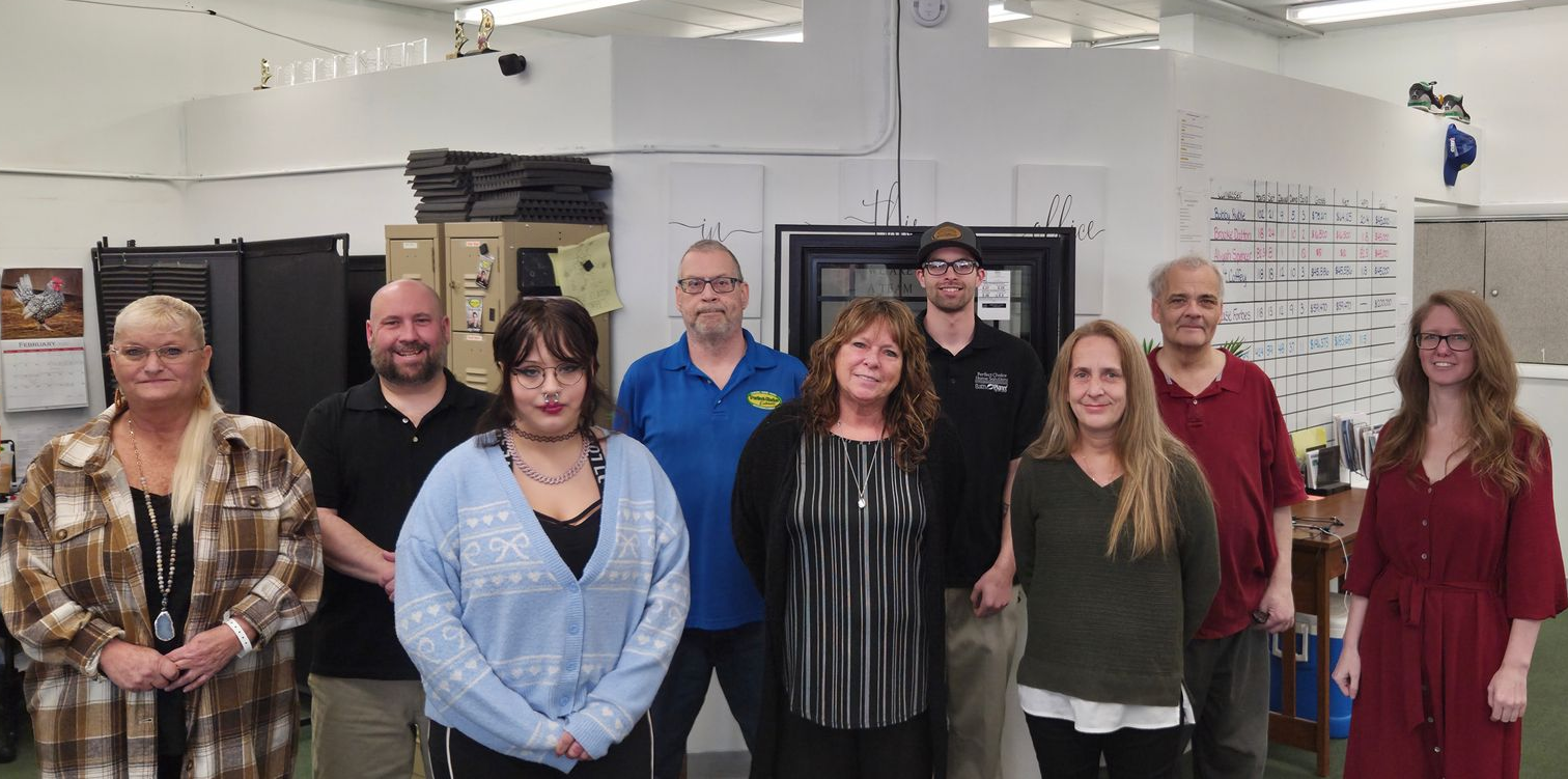 A group of people standing close together in an industrial setting at Perfect Choice Home Solutions in Creve Coeur, Illinois.