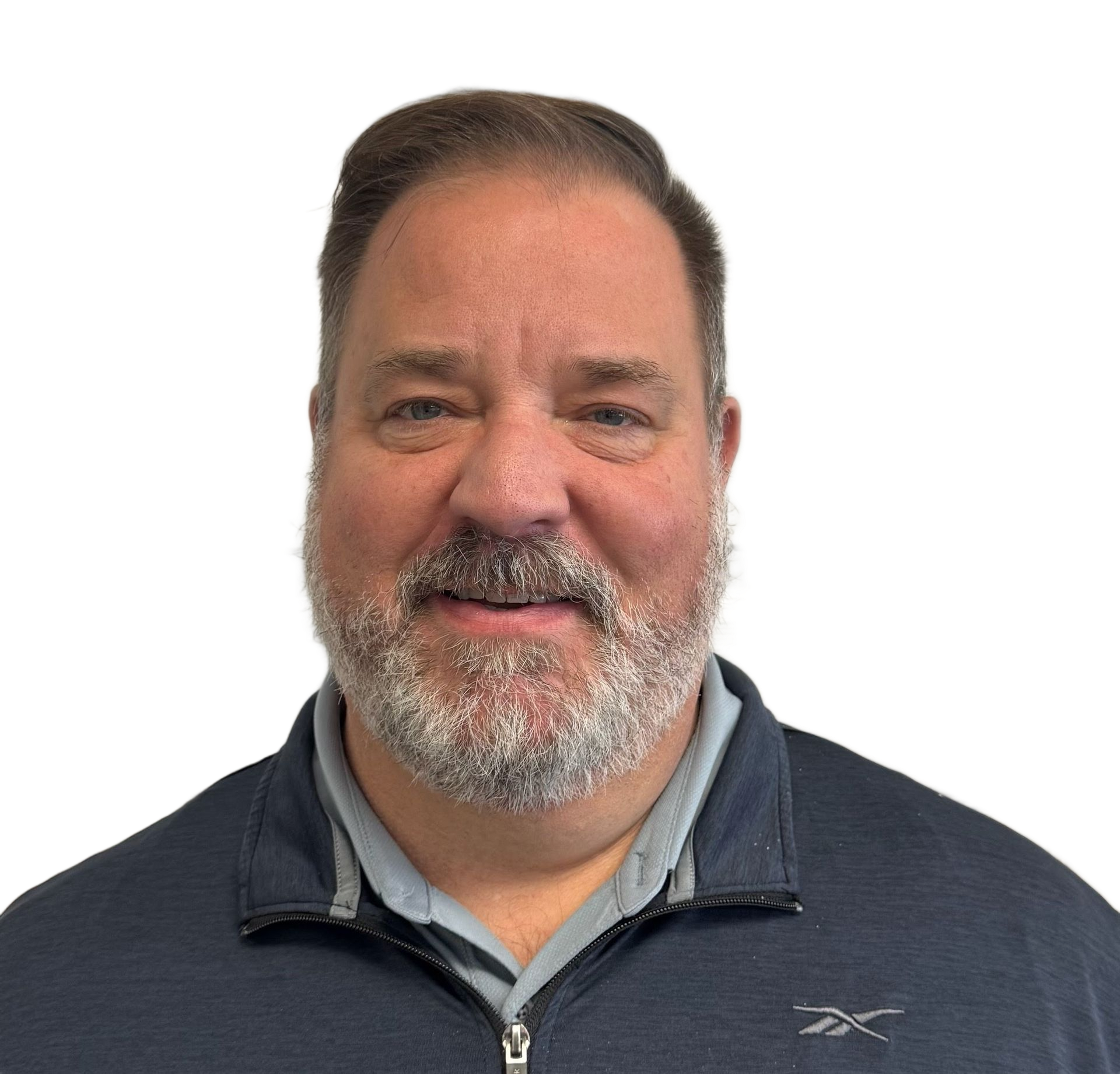 Man with graying hair smiling, wearing a blue zip up shirt against a white background.