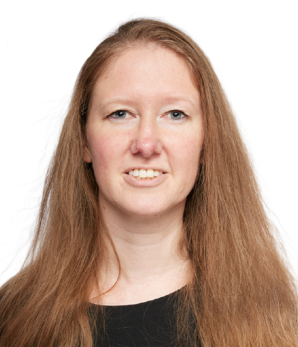 Woman smiling in a black sleeveless top against a white backdrop.