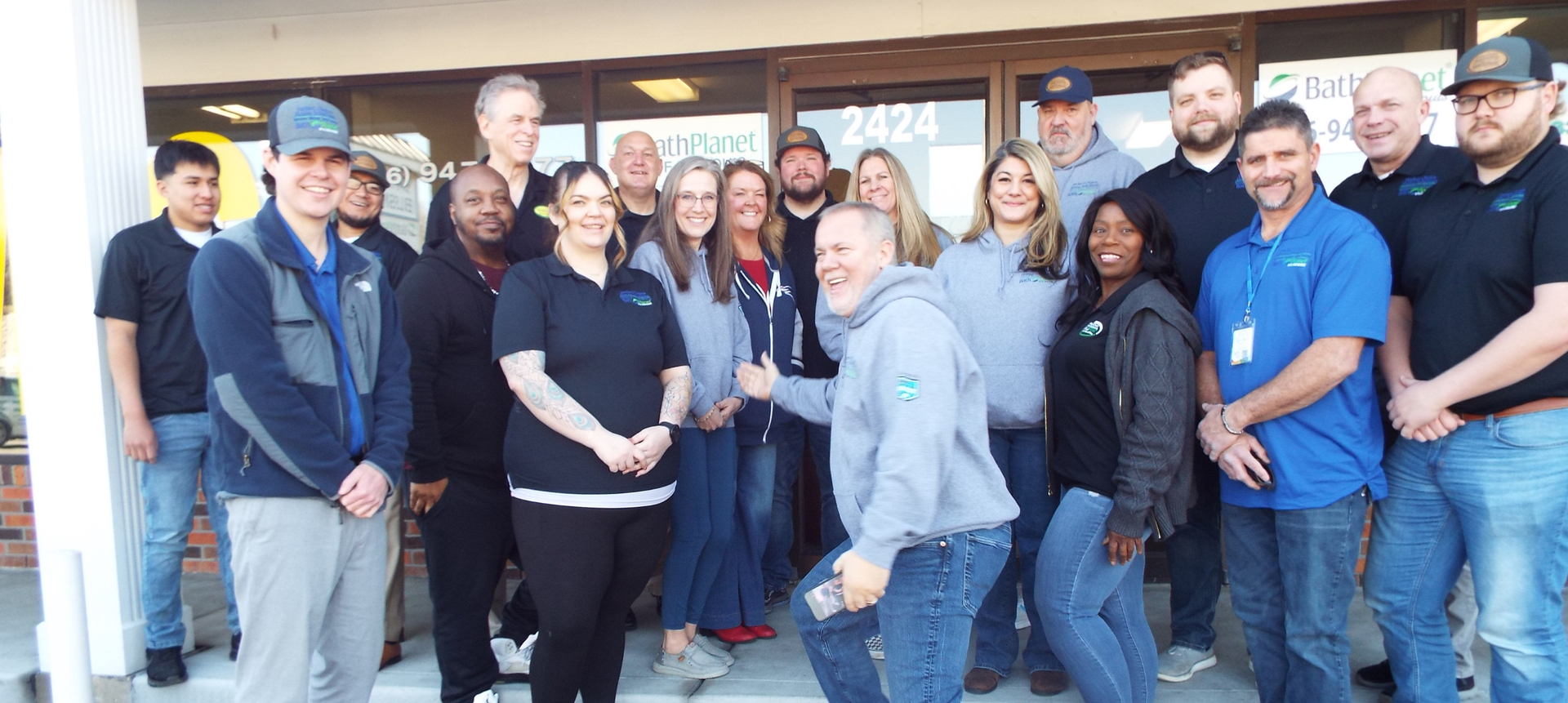 Group of people standing in front of a building; some are smiling. At Perfect Choice Home Solutions.