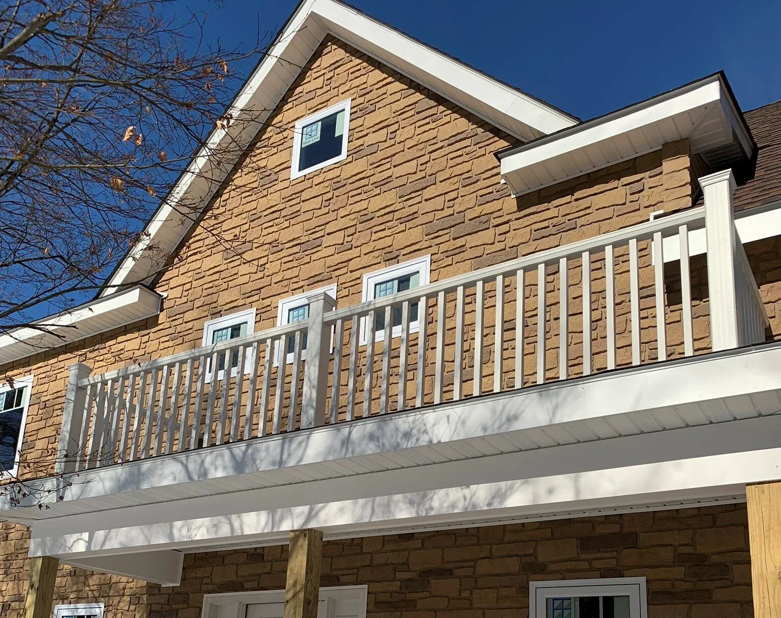 Green house with white trim, front door porch with steps, and windows.