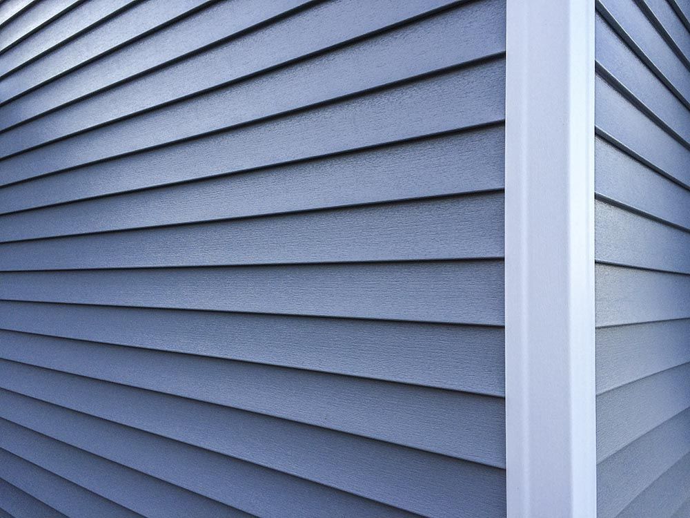 Blue siding on a building's exterior corner, white trim.