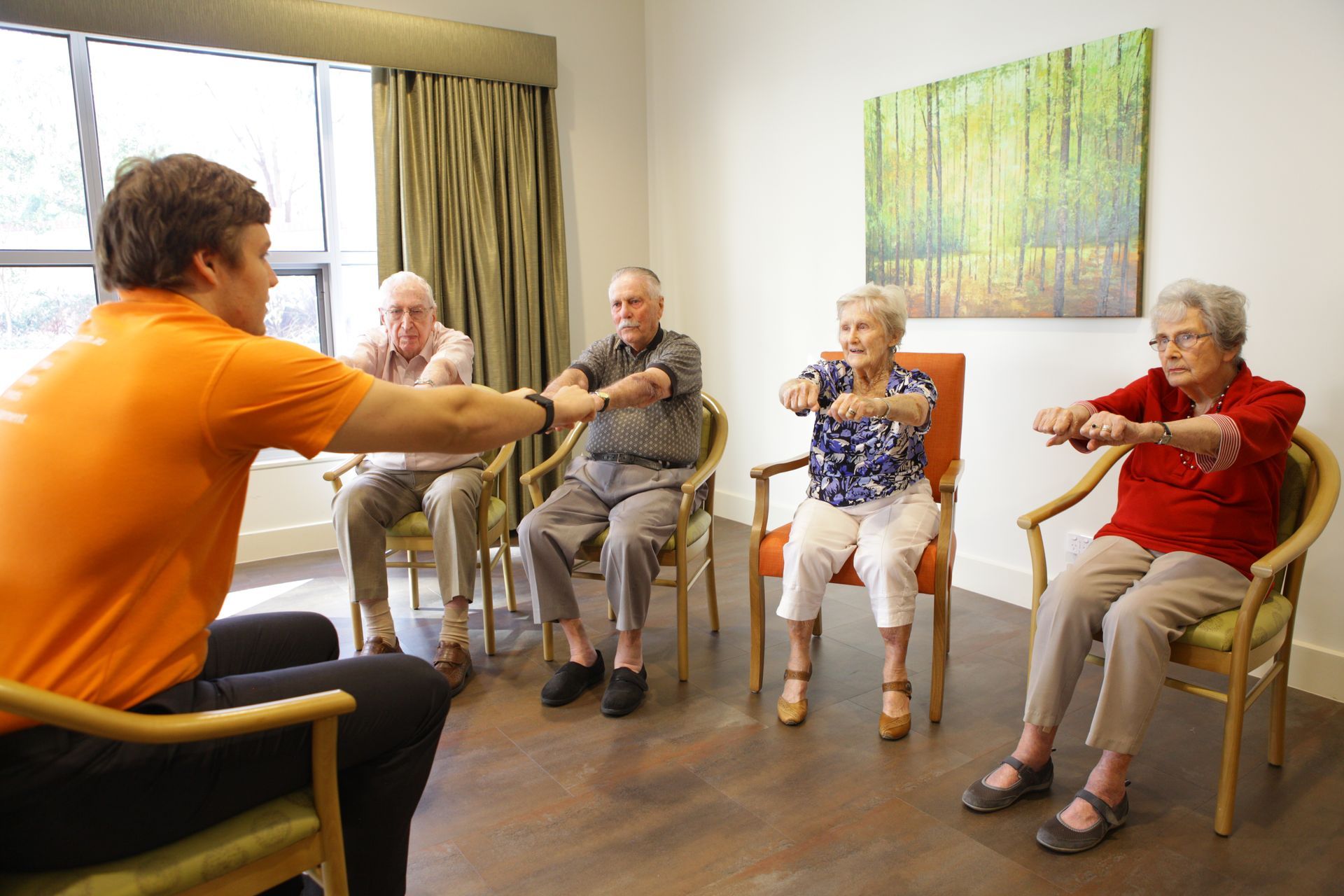 A group of elderly people doing stretching exercises with a Vivir Healthcare Physiotherapist
