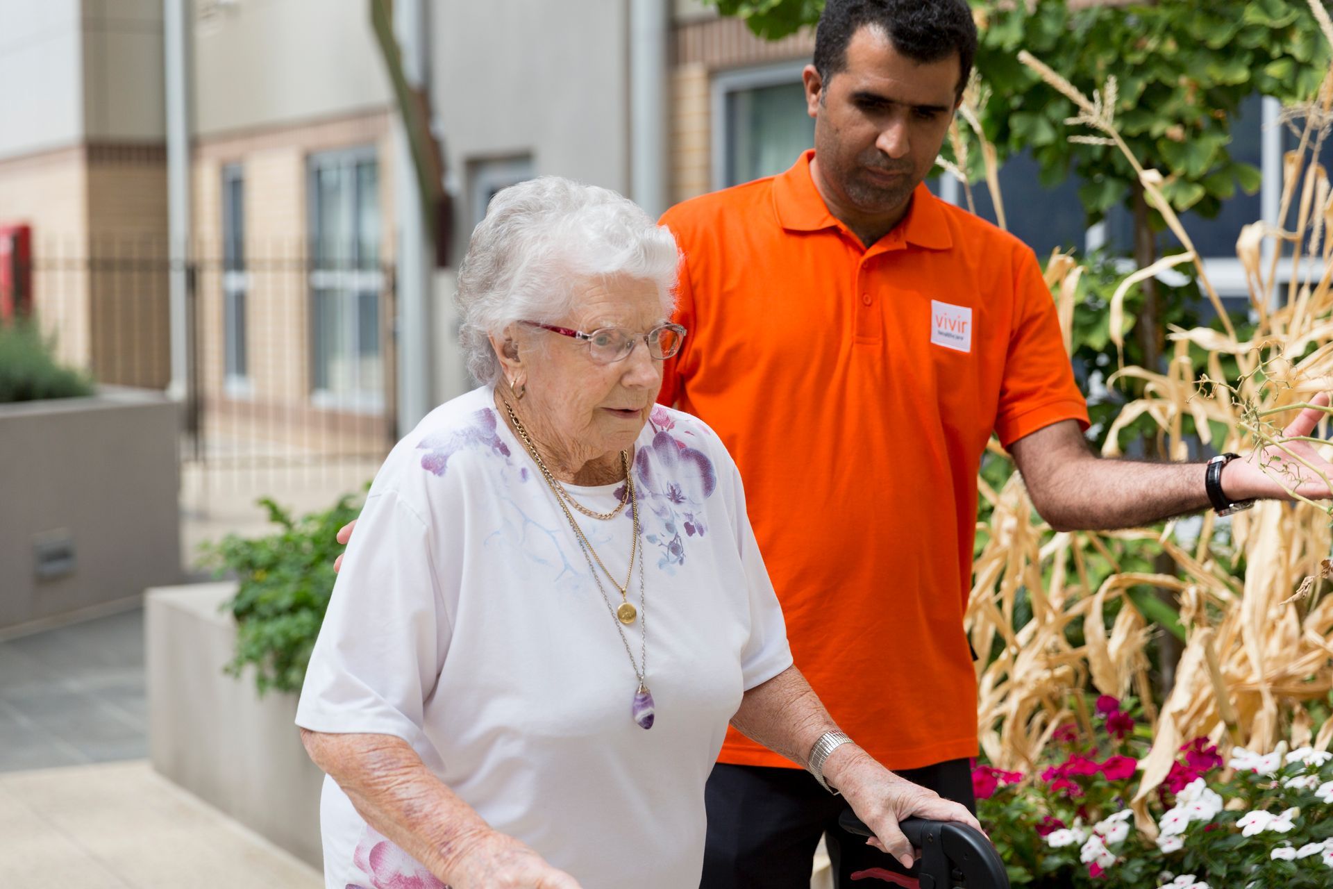 Vivir Healthcare Physiotherapist helping an elderly woman walk.