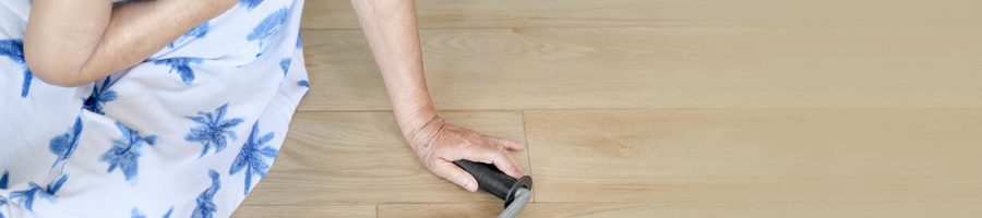 A woman is using a vacuum cleaner to clean a wooden floor.