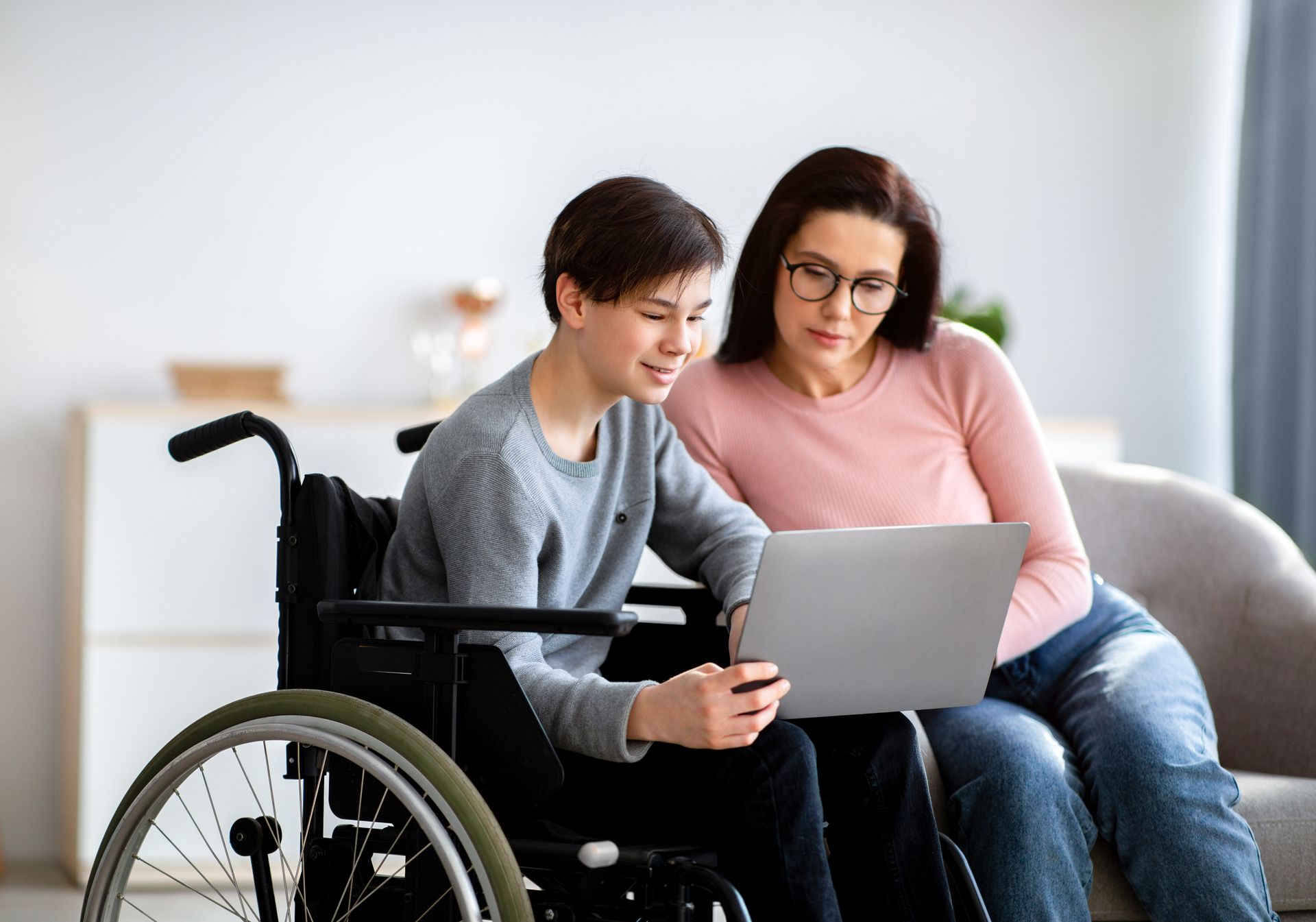 Disabled boy and his mother attending a Vivir Healthcare telehealth session 