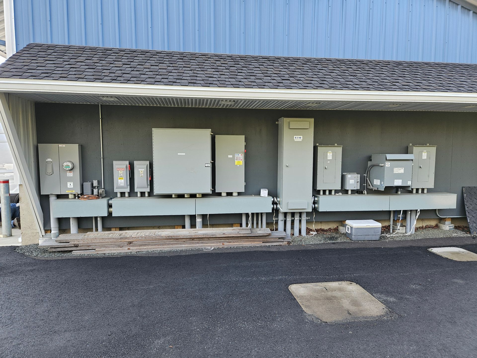 A row of electrical boxes are lined up on the side of a building.